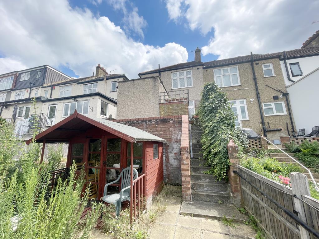 Lot: 132 - END-TERRACE HOUSE WITH DOUBLE GARAGE REQUIRING MODERNISATION - Outside image of property looking back up from garage